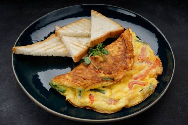 Omelet with vegetables and toast on a plate