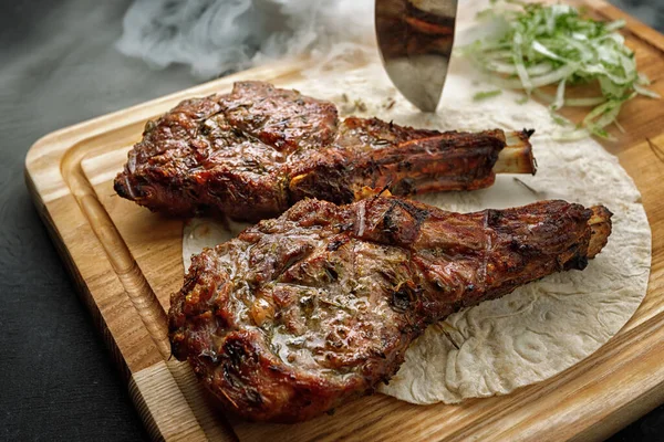Chalagach grilled with smoke on a wooden board with a knife
