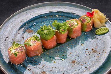 Sushi roll with tuna and salmon on a plate, on gray concrete