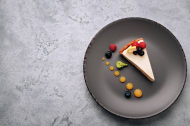 Cheesecake with berries, on a plate on a white concrete