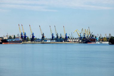 Vinçleri ve gemileri olan kargo iskelesi. Mavi gökyüzü. Yatay