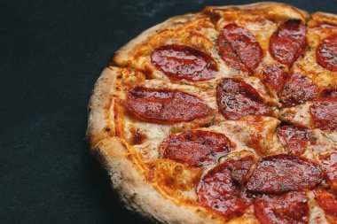 Gri betonda sosis ve baharatlı çıtır pizza.