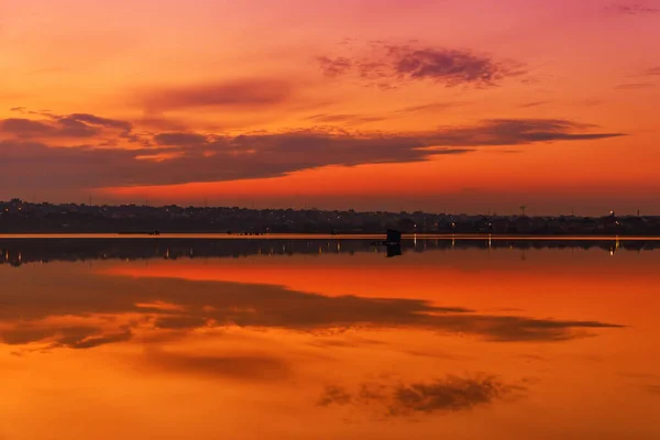 Sunset on the lake with reflection and mirror surfaces