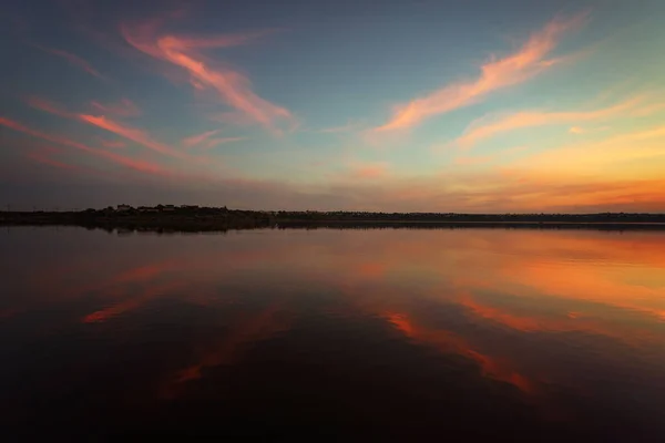Unique sunset over the lake with a mirror reflection of the clouds. mirror water