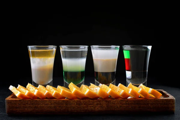 Klassisch Geschichtete Cocktails Auf Einem Holzbrett Mit Orangenscheiben Auf Schwarzem — Stockfoto