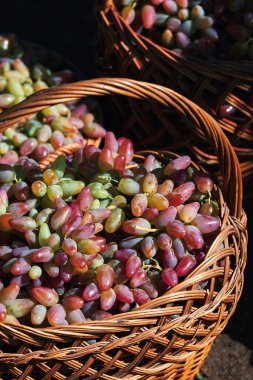 Tahta hasır sepetlerde bir sürü olgun üzüm var. Dikey