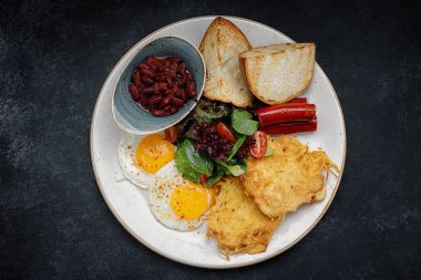 İngiliz kahvaltısı, kızarmış sosis, fasulye ve kızarmış yumurta.