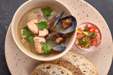 Deniz ürünleri çorbası, midye balığı, balık çorbası, siyah arka planda.