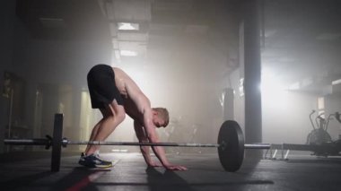 Adam spor salonunda burpee egzersizi yapıyor. Yüksek yoğunluklu ara eğitim. Burpee egzersizi yapan genç adam.