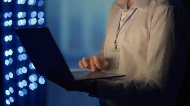 Sunucu odasında dizüstü bilgisayarla çalışan bir adamın portresi. Teknisyen sunucu odasında check-up yapıyor. Beyaz mühendis gri işçi ceketi giyiyor.