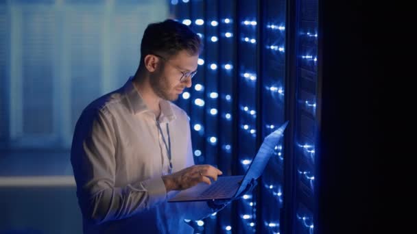 データセンターのデジタルサーバールームのIT技術者は、タブレットでラックサーバーキャビネットの作業を制御します。仕事中のプロのサーバーエンジニア. — ストック動画