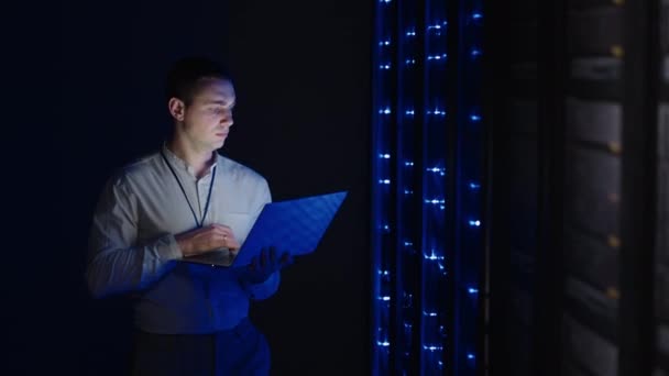 Bilgi Dijitalleştirme Konsepti: Bilgi Teknolojisi Uzmanı Sunucu Rafları 'nın önünde dizüstü bilgisayarla duruyor, Veri Merkezi' ni dokunmatik bir hareketle etkinleştiriyor. Ağ Verisi — Stok video