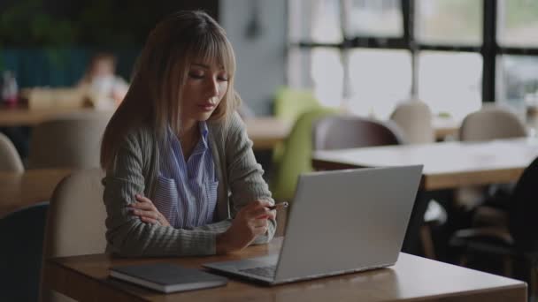 Uma mulher asiática senta-se e olha para uma tela de laptop. Brainstorm e ansioso na cara. Brooding mulher asiática — Vídeo de Stock