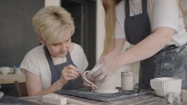 Tre ældre mennesker arbejder på et pottemagerhjul i slowmotion – Stock-video