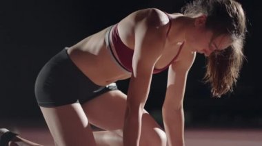 Ağır çekimde bayan koşucu başlangıçta yakın çekimde stadyumdaki profesyonel atletizm atletizminde.