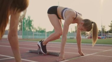 Kadınların koşu ve saha yarışı eskidi. Gün batımında stadyumda üç kadın koşuyor. Çalıştırma başlangıcı