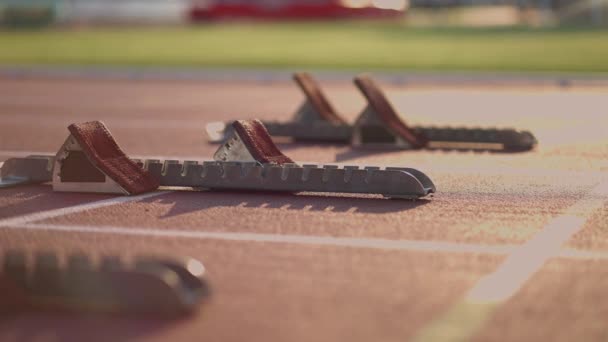 Närbild tre kvinnliga spår och vattensporter på startlinjen på stadion tävlingen förbereda och springa iväg i en sprint race. — Stockvideo