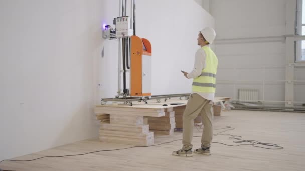 Инженеры следят за работой лазерной печати принтера на стене в помещении — стоковое видео