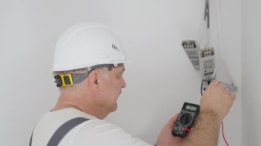 Erkek bir elektrikçi akıllı bir ev sistemine aydınlatma için trafolar yerleştiriyor. Kurulum Denetim Işıklandırması