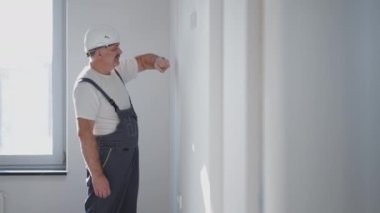 Elektrikçi dairedeki ışıklandırmayı açar ve ışığa bakar.