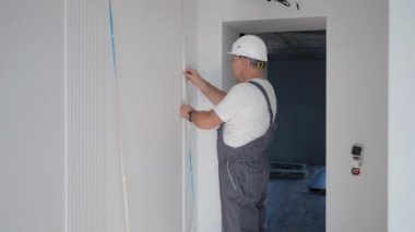 Erkek bir elektrikçi, akıllı ev sistemindeki duvarları aydınlatmak için LED şerit takıyor. Kurulum Denetim Işıklandırması