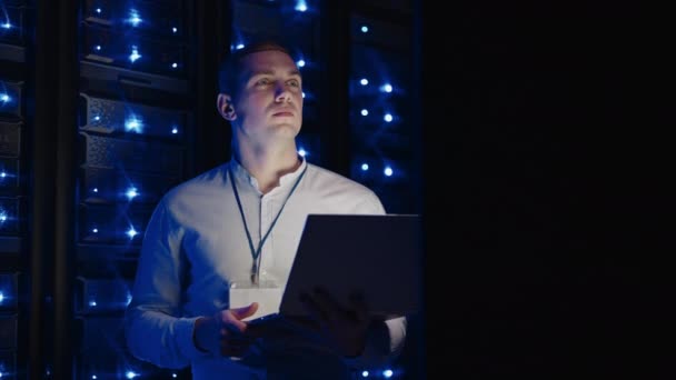 Ένας μηχανικός υπολογιστών εξετάζει και διορθώνει τα προβλήματα δωμάτιο διακομιστή. Σύγχρονη ειδικός πληροφορικής εργάζεται σε ένα σύστημα αποθήκευσης σύννεφο — Αρχείο Βίντεο