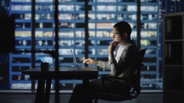 Távmunka, egy férfi dolgozik otthonról egy laptopon éjszaka. — Stock videók