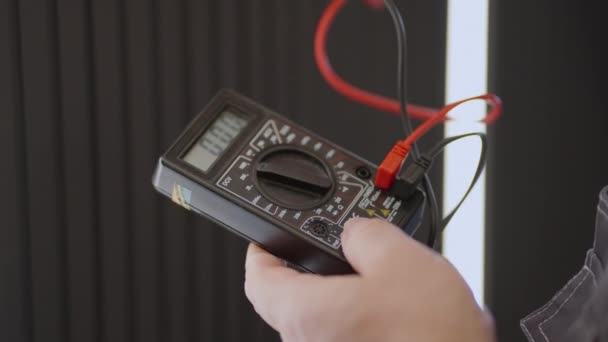 Primer plano del dispositivo de un electricista en funcionamiento que comprueba la presencia de tensión en la red — Vídeos de Stock