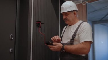 Portre Elektrikçisi, lamba duvar kontrol ünitesinin kurulum ve onarım sonrasında modern ev sistemiyle çalışmasını kontrol eder