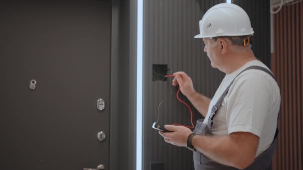 Pemandangan dari belakang Pemeriksaan listrik terhadap pengoperasian unit kontrol dinding lampu dengan sistem rumah modern setelah pemasangan dan perbaikan — Stok Video