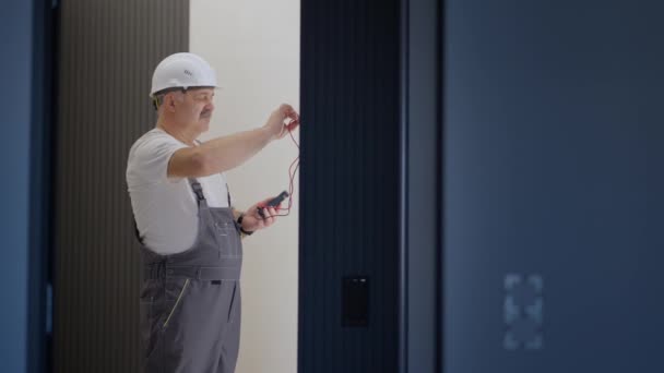 Homme électricien installe et contrôle le fonctionnement du système de maison intelligente dans l'appartement — Video