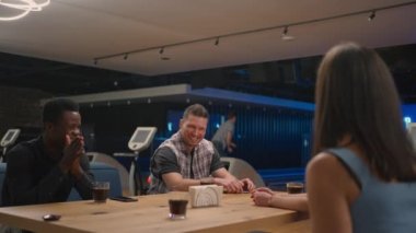 Adam bir bowling salonunda grev yapıyor ve arkadaşlarına koşup birlikte seviniyor ve zaferi kutlamak için arkadaşlarıyla birlikte beş dakika veriyor. Çok ırklı arkadaş takımı.