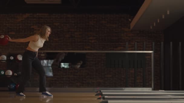 Einsame kaukasische Blondine wirft eine Bowlingkugel und schlägt ein Shooting mit einem Wurf aus Tänzen jubelt und springt vor Glück — Stockvideo