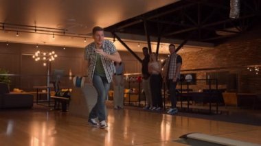 Bowling salonunda bir adam topu piste atar ve yavaş çekimde bir şutu indirir ve zevk için zıplar ve dans eder. Bir grup çok ırklı arkadaş birlikte bowling oynuyorlar. Mutlu alkışlıyorlar, destekliyorlar.
