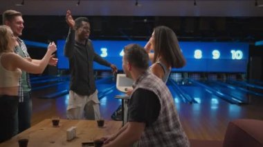 Bowling kulübündeki siyah bir adam beş arkadaşının nakavt serisini kutlamasına izin veriyor. Zaferi arkadaşlarınla paylaş. Çok ırklı arkadaş grubu