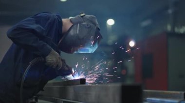 Kaynakçı metal kaynaklama yapar. Özel maskeli kaynakçı, metal parçaları parlak kıvılcımlarla birbirine bağlar. Özel maskeli kaynakçı, metal parçaları parlak kıvılcımlarla birbirine bağlar.