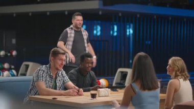 Bowling kulübündeki neşeli bir adam yere düşen havayı kutlamak için arkadaşlarına koşar. Zaferi arkadaşlarınla paylaş. Çok ırklı arkadaş grubu