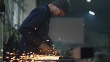 Koruyucu gözlüklü bir adam metal cilalama ve çelik metal yapıları sökme işinde çalışır. Yavaş çekim