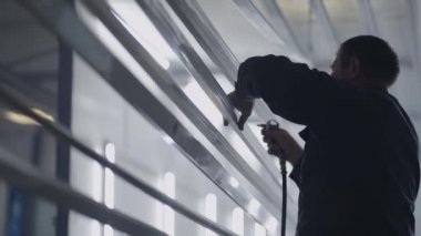 Azı dişi atölyesi ve işçiler yavaş çekimde resim yapmadan önce toz ve parçacıkların çelik profillerini işlerler.