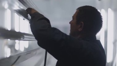 Bir azıdişi atölyesi ve işçi yavaş çekimde resim yapmadan önce toz ve parçacıkların çelik profillerini işlerler.
