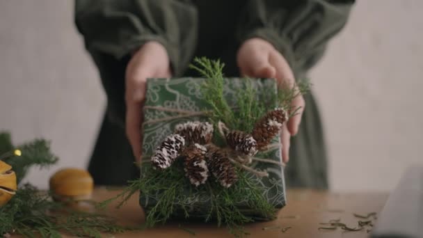 A Christmas present moves a womans hands into the camera. Green Packaged Gift Woman Moves Into Camera After Packing and Decorating — Stock Footage A Christmas present moves a womans hands into the camera. Green Packaged Gift Woman Moves Into Camera After Packing and Decorating Royalty Free Stock Video