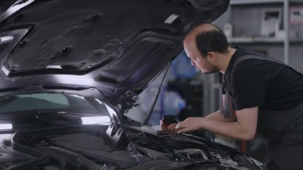 Usando la tableta digital para un diagnóstico del coche. mecánico utilizando una tableta PC en el servicio de reparación. Software de diagnóstico interactivo en una computadora avanzada. — Vídeo de stock