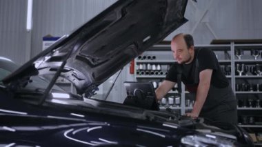 Araba teşhisi için dijital tablet kullanılıyor. Tamir servisinde tablet bilgisayar kullanan bir tamirci. Gelişmiş Bilgisayarda Etkileşimli Tanılama Yazılımı.