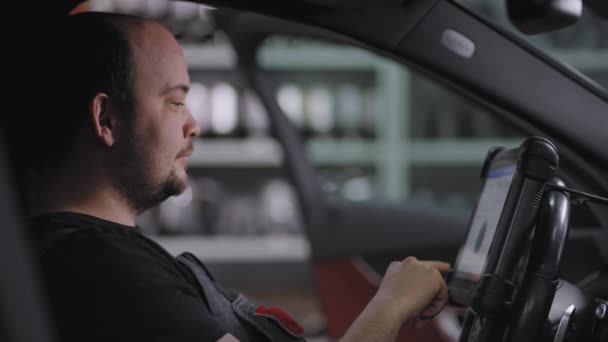 Primer plano: Usando la tableta digital para un diagnóstico del coche. mecánico utilizando una tableta PC en el servicio de reparación de garaje. Software de diagnóstico interactivo en una computadora avanzada. — Vídeos de Stock