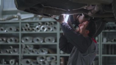 Araba asansörde kalkıyor ve tamirci arabanın süspansiyonuyla ilgili sorun ve teşhisi koyuyor.