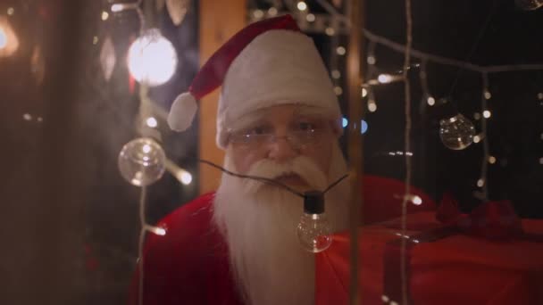 Portret van de Kerstman die uit het raam kijkt en zijn vinger in zijn gezicht steekt en zegt shh — Stockvideo