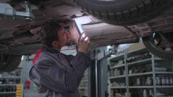 El mecánico inspecciona el día del coche en el ascensor — Vídeos de Stock