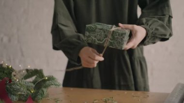 Yakın plan kız hediyeyi sarıp iple bağlıyor.