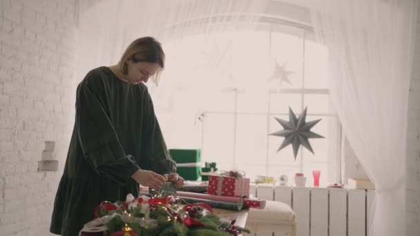 Una mujer empaca regalos en Nochebuena — Vídeo de stock