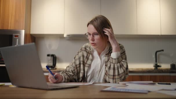 Una mujer con gafas Estudiante de educación a distancia en casa para realizar una tarea en economía — Vídeo de stock